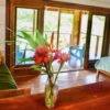 A vase of flowers on the table in front of a window.