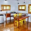 A kitchen with wooden floors and yellow chairs.