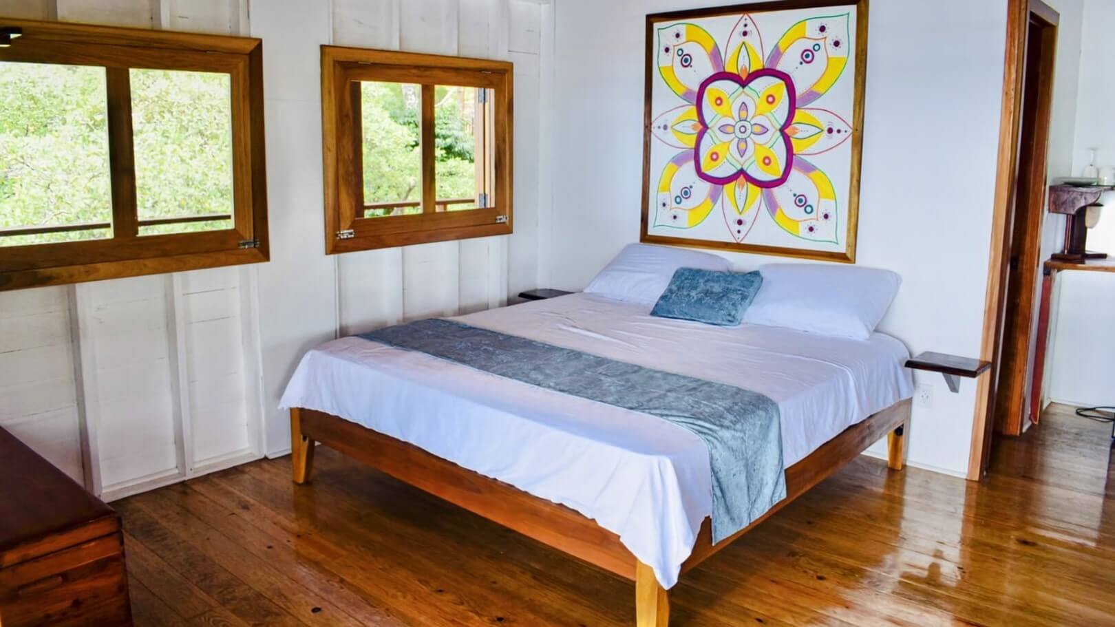 A bed room with a large painting on the wall