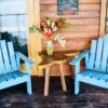 Two blue chairs and a table with flowers on top of it.