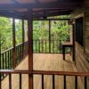 A porch with wooden floors and a bench.