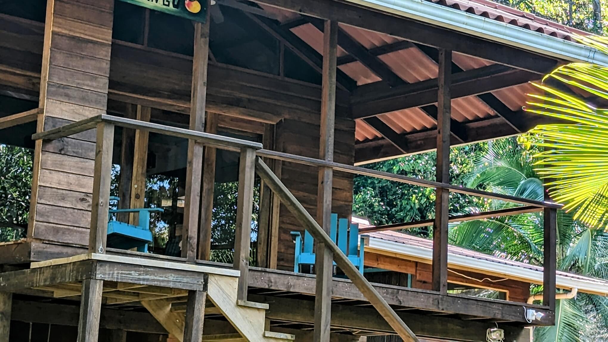 A wooden deck with blue chairs and a fire hydrant.