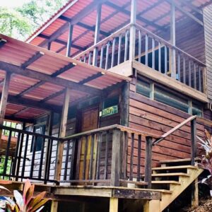A wooden house with stairs going up to it.